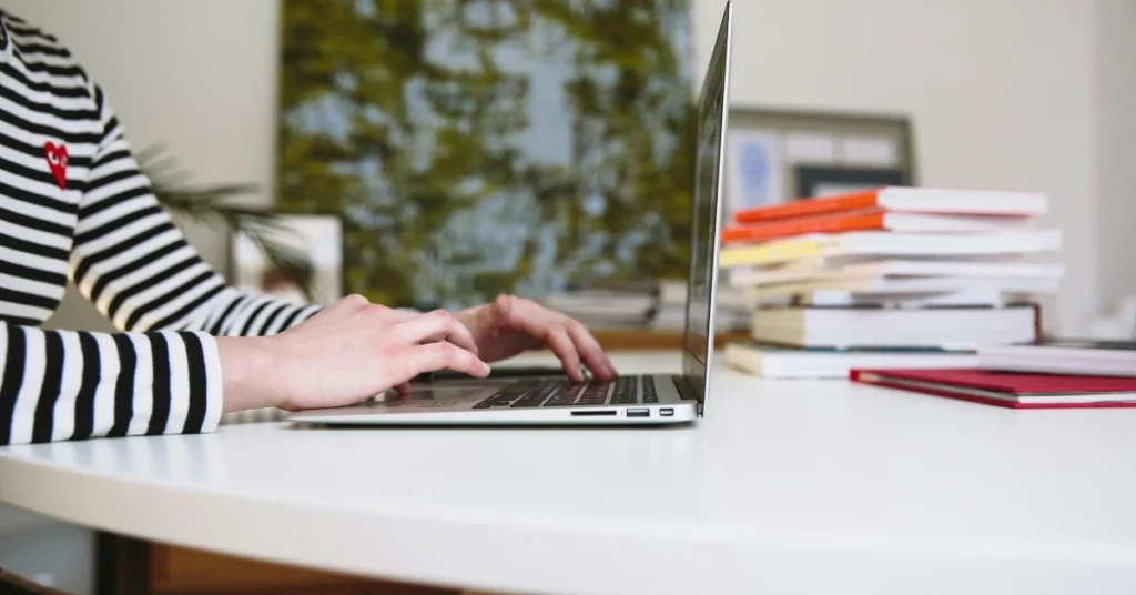 student typing on a laptop