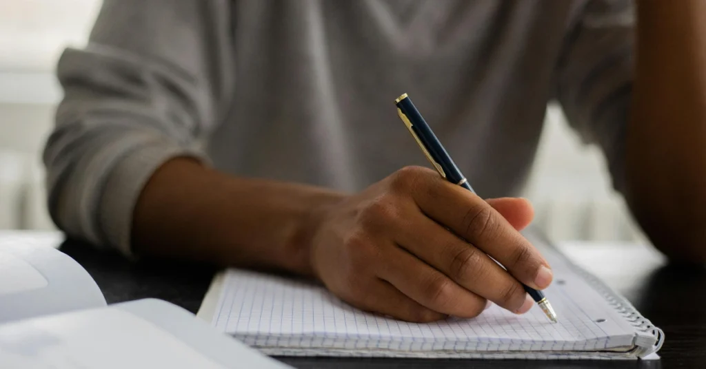 student writing in notebook