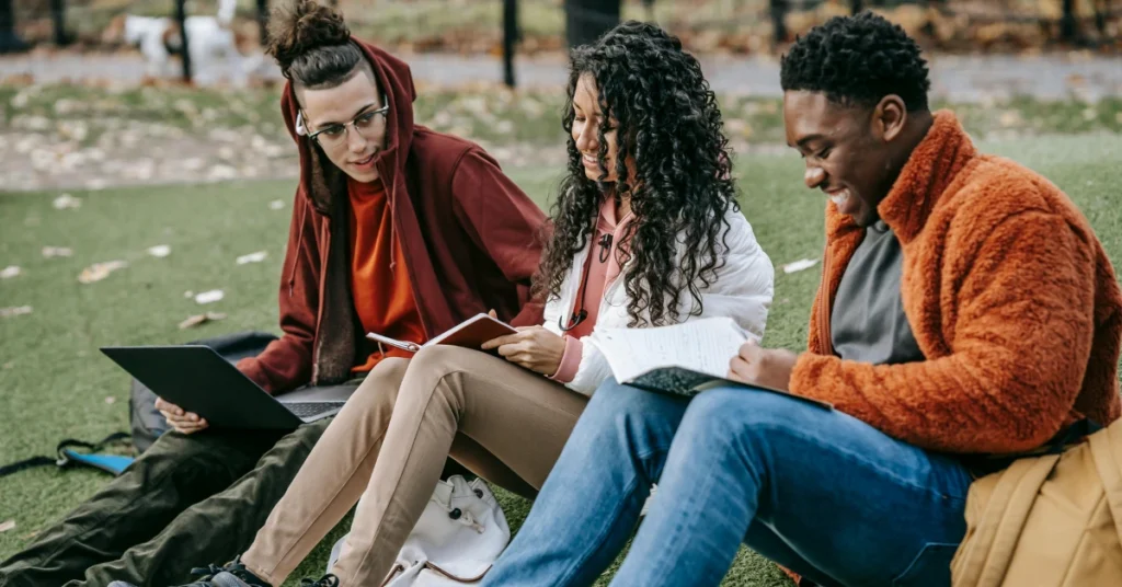 students studying in park at a university campus