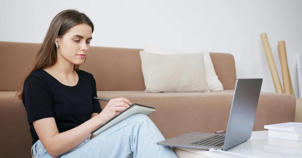 Student using laptop and taking notes